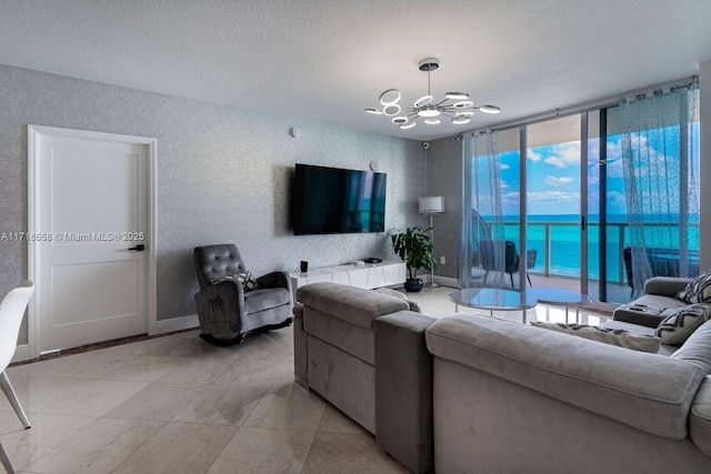 living room with a chandelier, a textured ceiling, and floor to ceiling windows