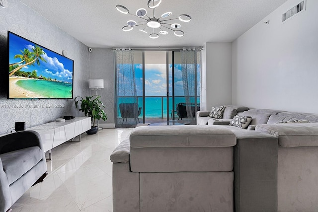 living room with a wall of windows, a textured ceiling, and an inviting chandelier