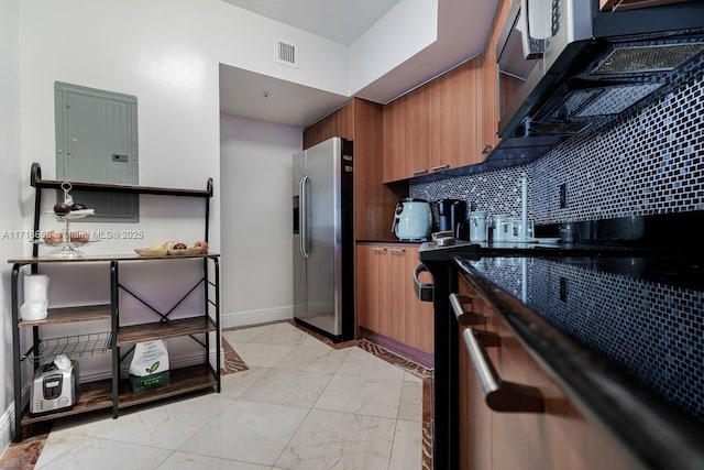 kitchen featuring electric panel, stainless steel fridge, and decorative backsplash