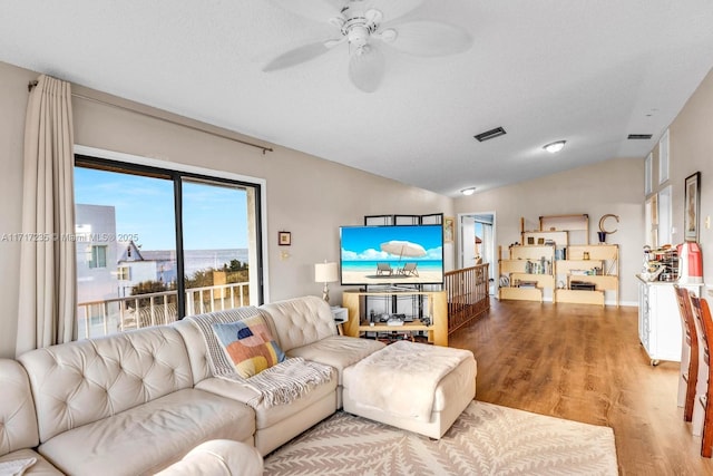 living room featuring a textured ceiling, ceiling fan, hardwood / wood-style floors, and lofted ceiling