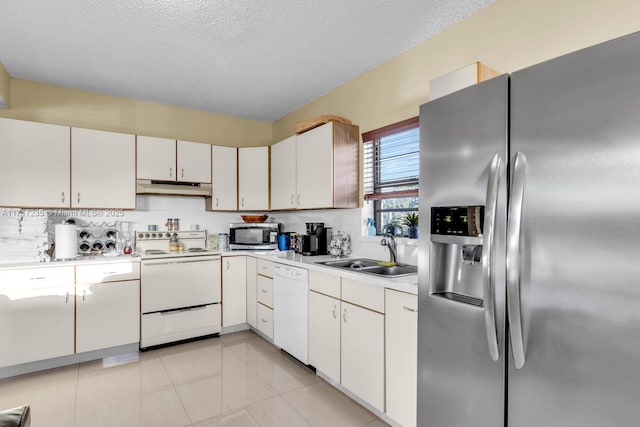 kitchen with appliances with stainless steel finishes, a textured ceiling, sink, white cabinetry, and light tile patterned flooring