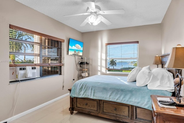 bedroom with ceiling fan and a textured ceiling