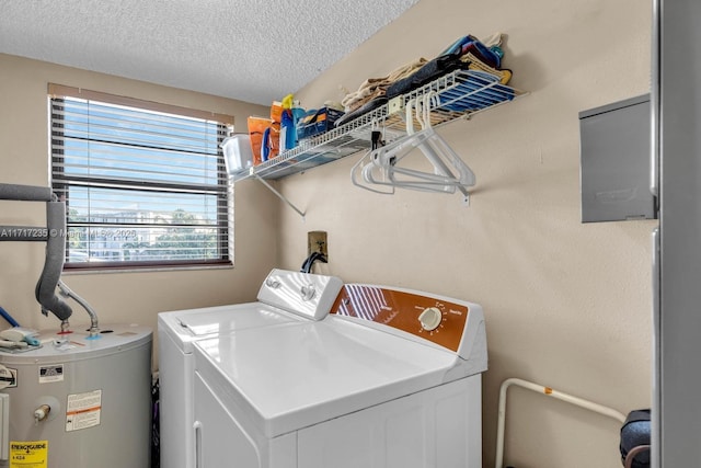 laundry area featuring washing machine and dryer, water heater, and a textured ceiling