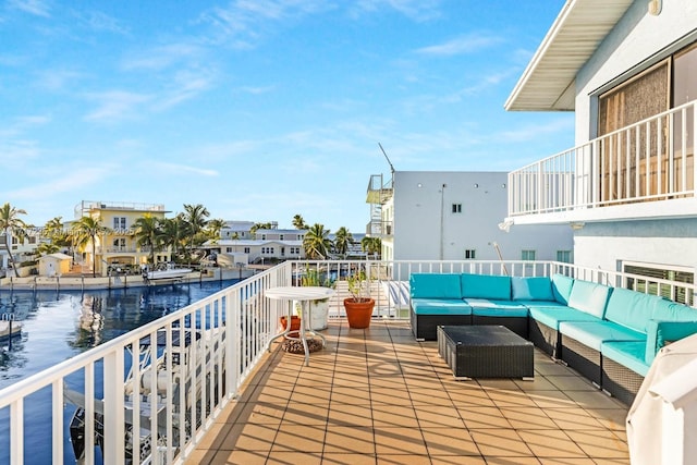 balcony featuring an outdoor living space and a water view