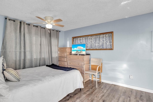 bedroom with wood-type flooring, a textured ceiling, and ceiling fan