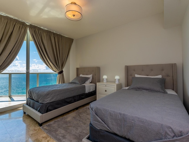 bedroom featuring access to exterior and a water view