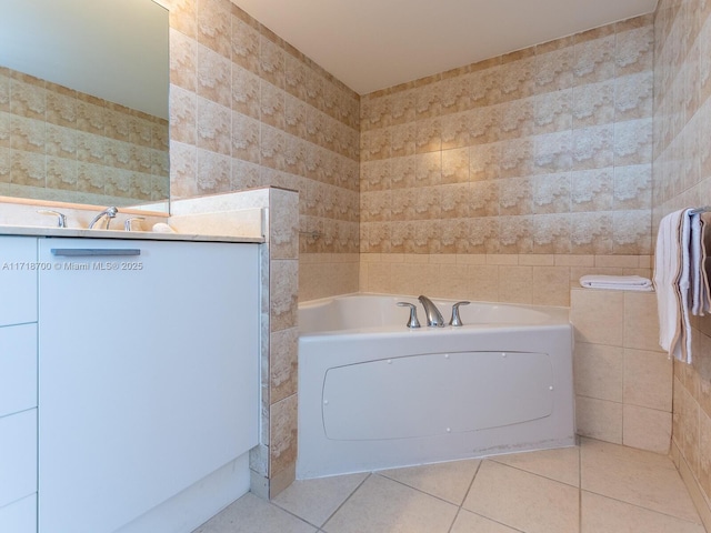 bathroom with a bath, tile patterned floors, tile walls, and sink