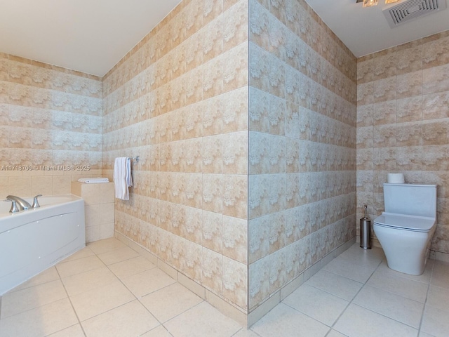 bathroom featuring tile patterned flooring, toilet, tile walls, and a bathing tub