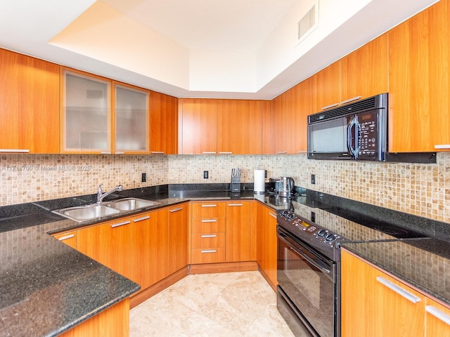 kitchen featuring backsplash, dark stone countertops, sink, and black appliances