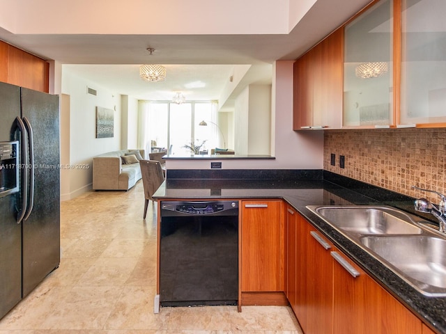 kitchen featuring black appliances, backsplash, sink, and dark stone counters