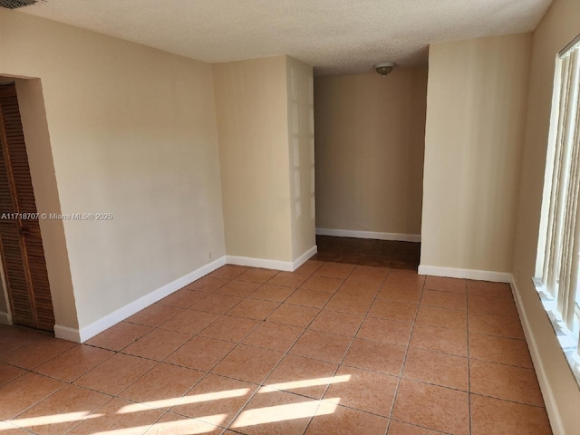 unfurnished room featuring light tile patterned floors and a textured ceiling