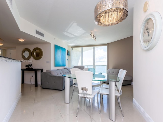 dining space featuring expansive windows, light tile patterned floors, and a notable chandelier