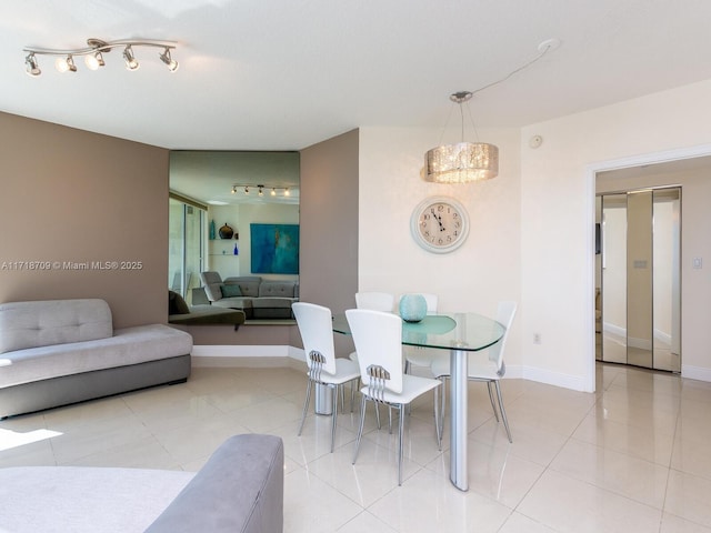 dining area featuring light tile patterned flooring and a notable chandelier