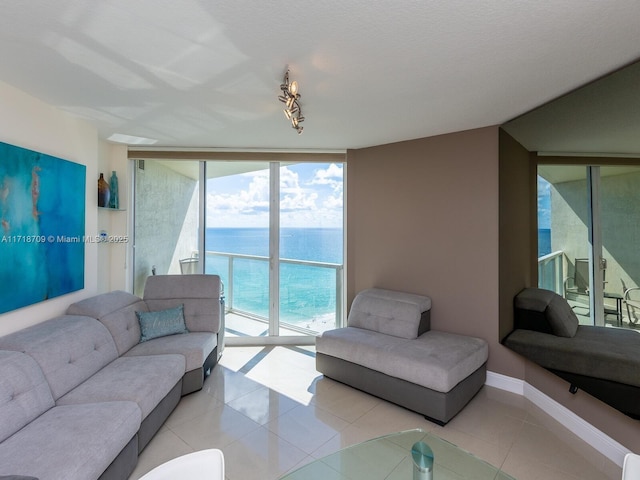 tiled living room featuring expansive windows and a water view