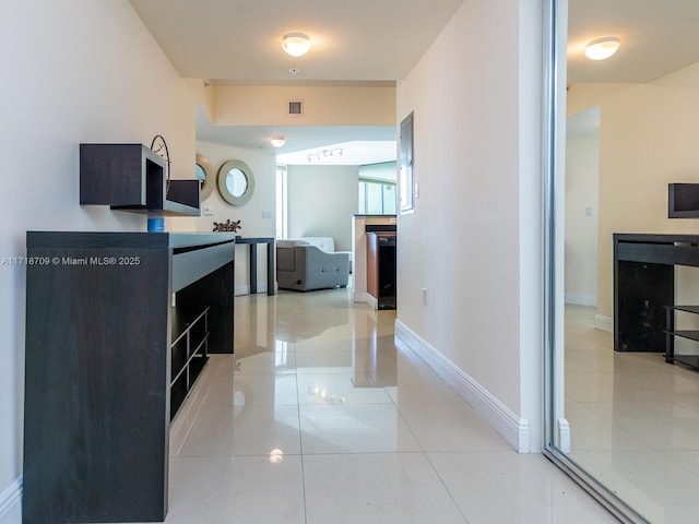 hall with light tile patterned floors