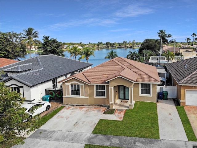 view of front of home with a front lawn and a water view