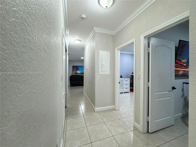 hallway with ornamental molding, a textured ceiling, and light tile patterned floors