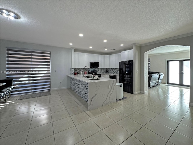 kitchen featuring backsplash, kitchen peninsula, white cabinetry, and a textured ceiling