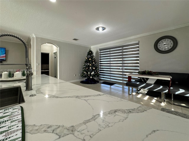 tiled dining space with crown molding and a textured ceiling