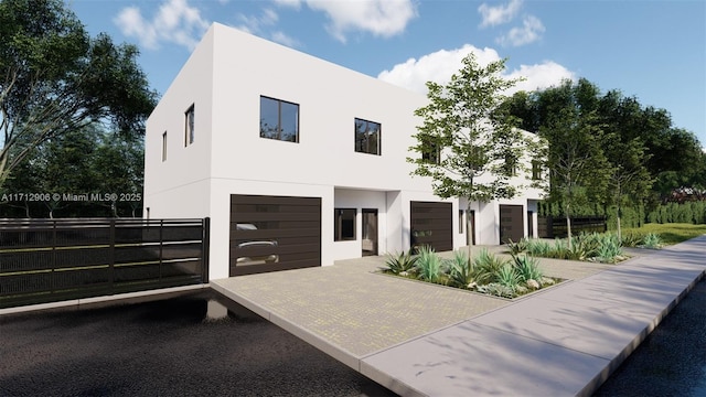 contemporary house featuring stucco siding, driveway, a garage, and fence