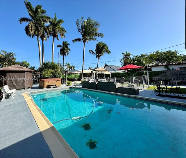 view of swimming pool featuring a hot tub, a patio, and an outdoor hangout area