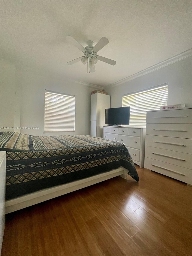 unfurnished bedroom featuring dark hardwood / wood-style flooring, crown molding, and ceiling fan