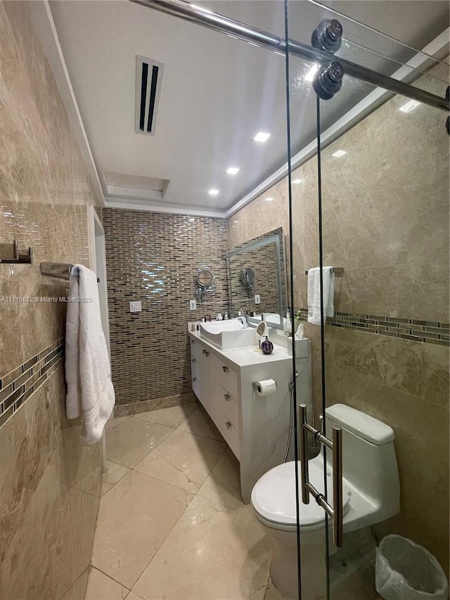 bathroom featuring vanity, a shower with shower door, tile walls, and toilet