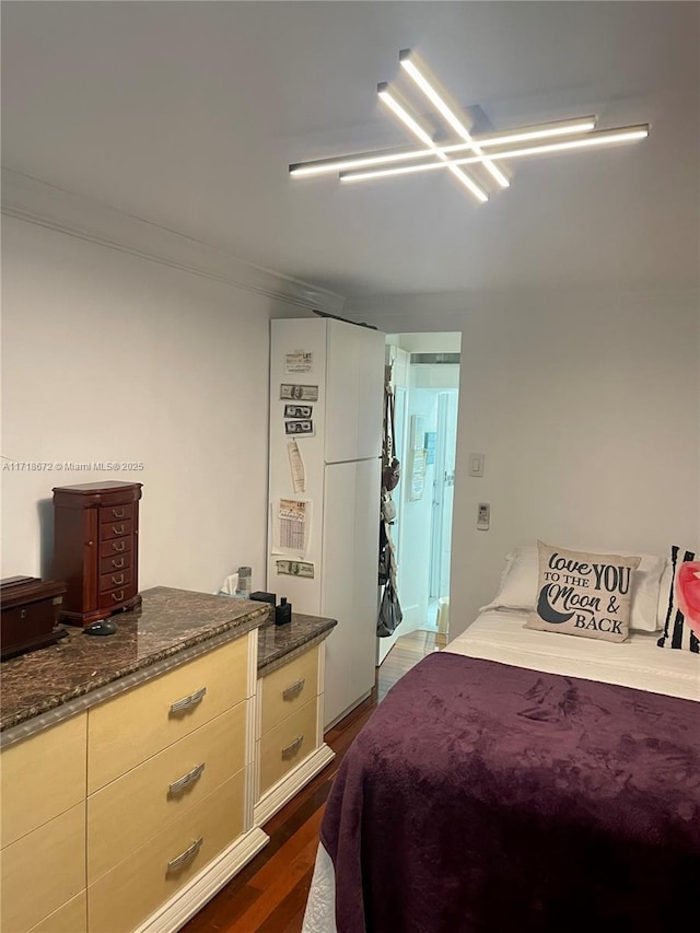 bedroom with crown molding and dark hardwood / wood-style flooring