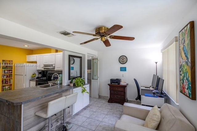 office area with ceiling fan, light tile patterned floors, and sink