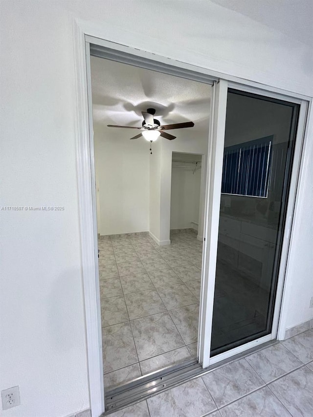 entrance to property with ceiling fan and a patio area