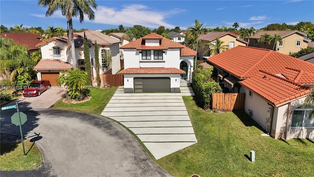 mediterranean / spanish home with a garage and a front lawn