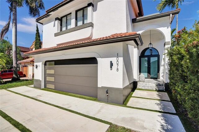 mediterranean / spanish-style home with a garage and a front lawn