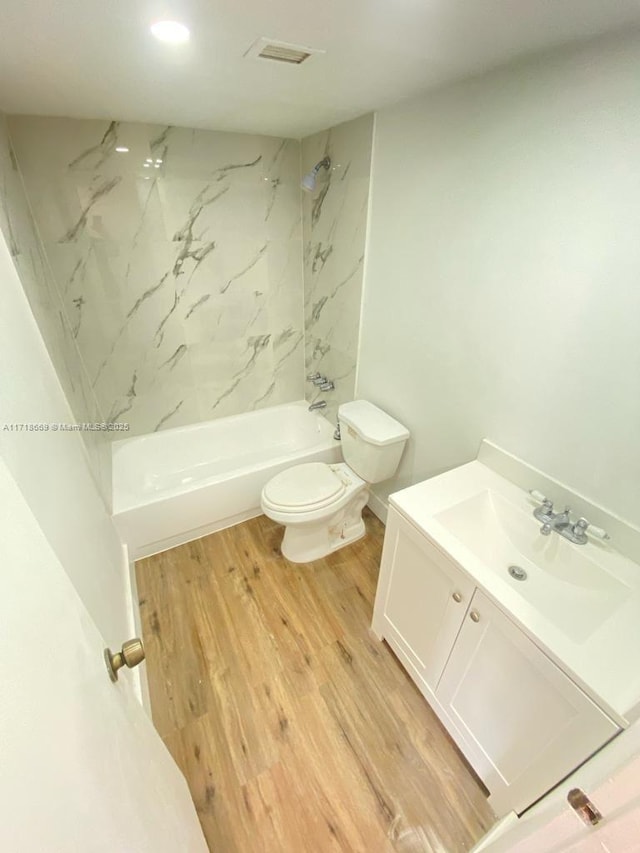 full bathroom with wood-type flooring, vanity, toilet, and tiled shower / bath