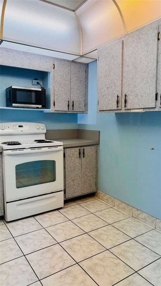 kitchen with electric stove and light tile patterned floors