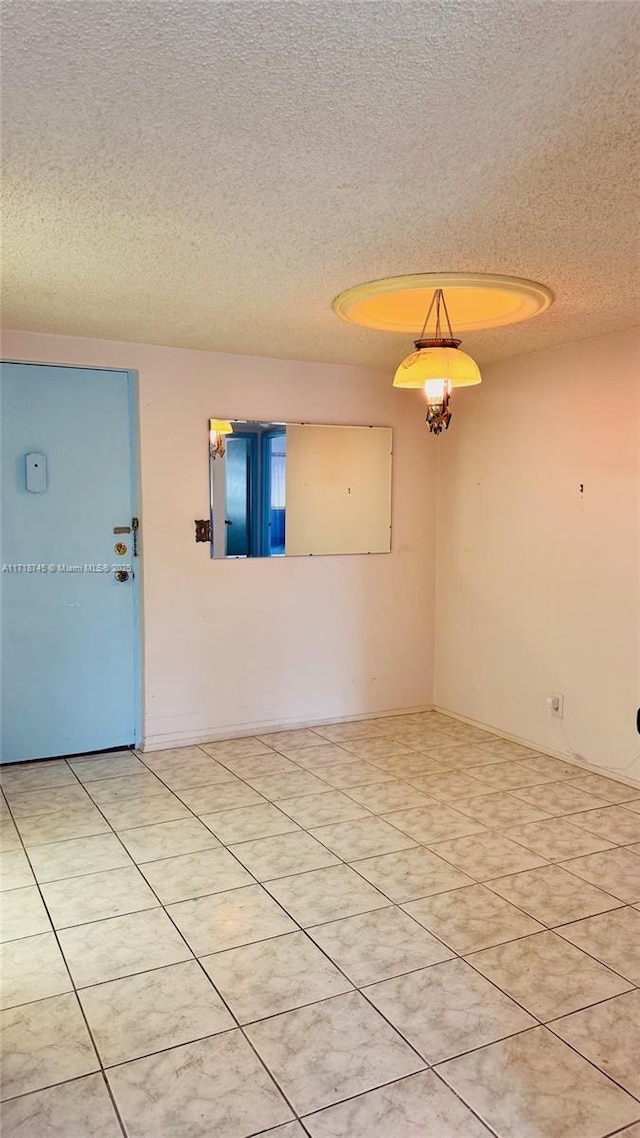 tiled spare room with a textured ceiling