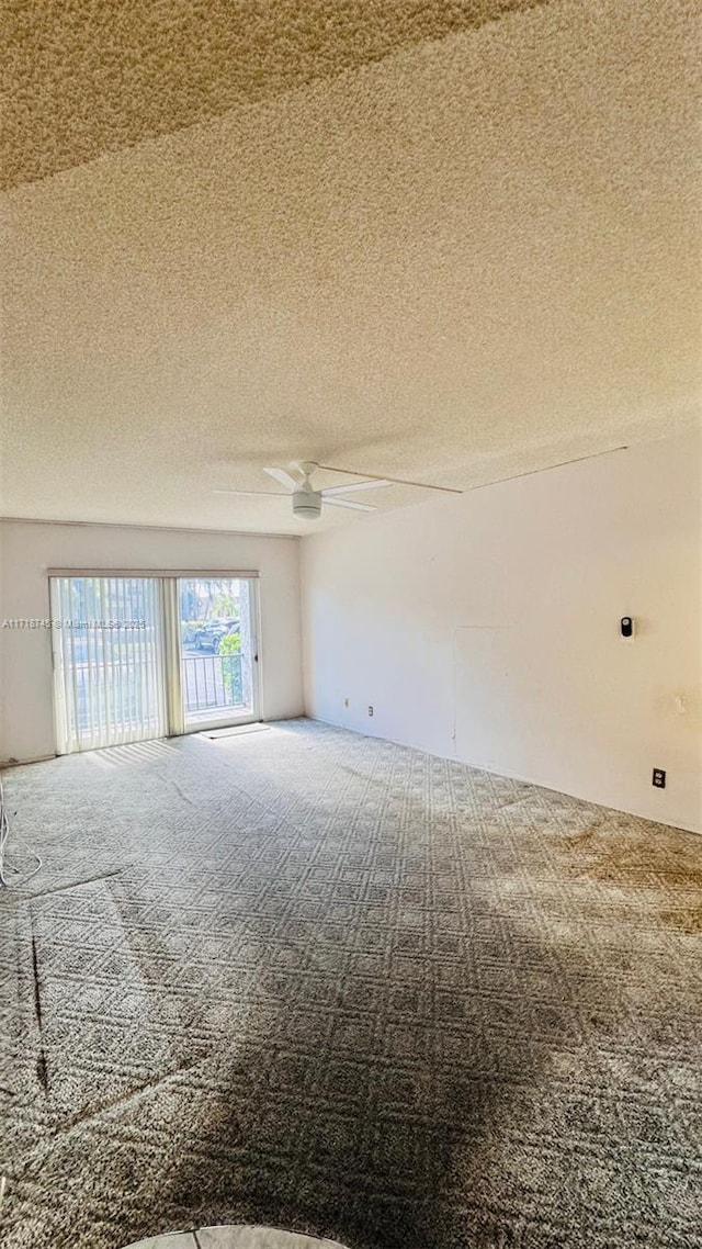 spare room with carpet, ceiling fan, and a textured ceiling