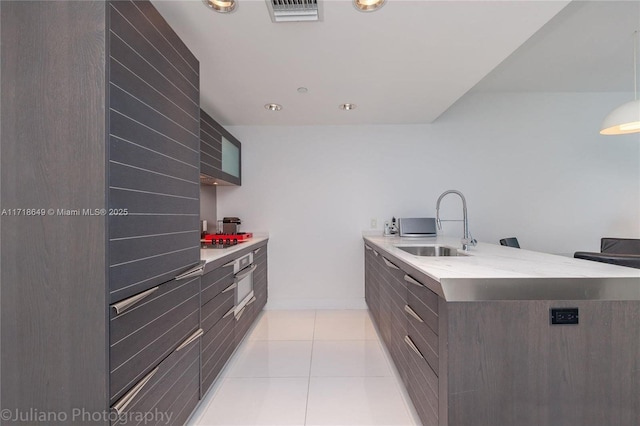 kitchen with appliances with stainless steel finishes, sink, and light tile patterned flooring