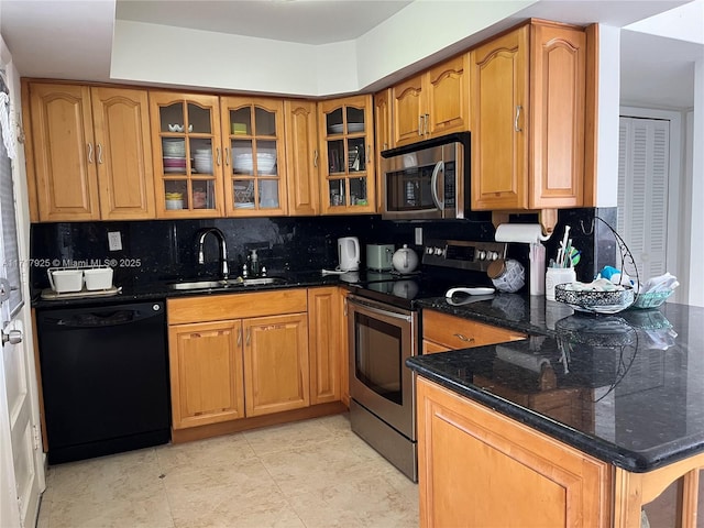 kitchen featuring sink, tasteful backsplash, light tile patterned floors, appliances with stainless steel finishes, and dark stone counters