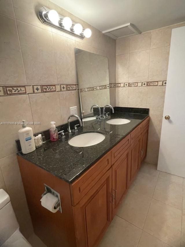 bathroom with tile patterned flooring, vanity, tile walls, and toilet