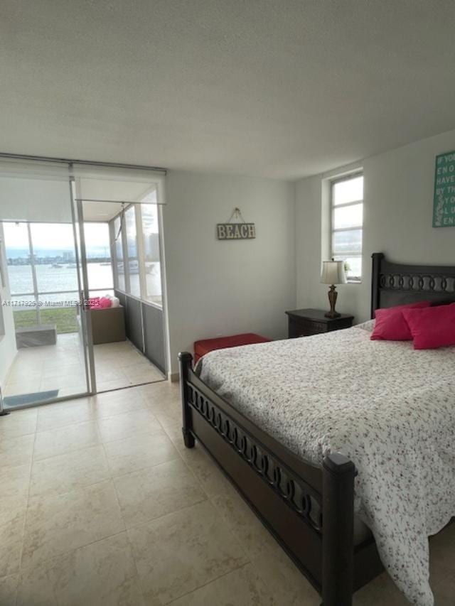 bedroom featuring a water view and access to outside