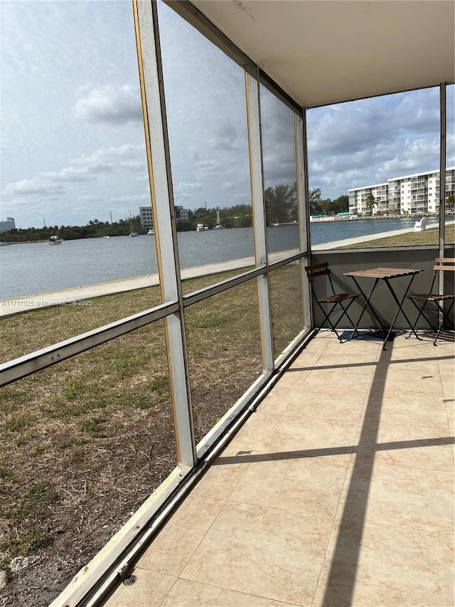 unfurnished sunroom featuring a water view