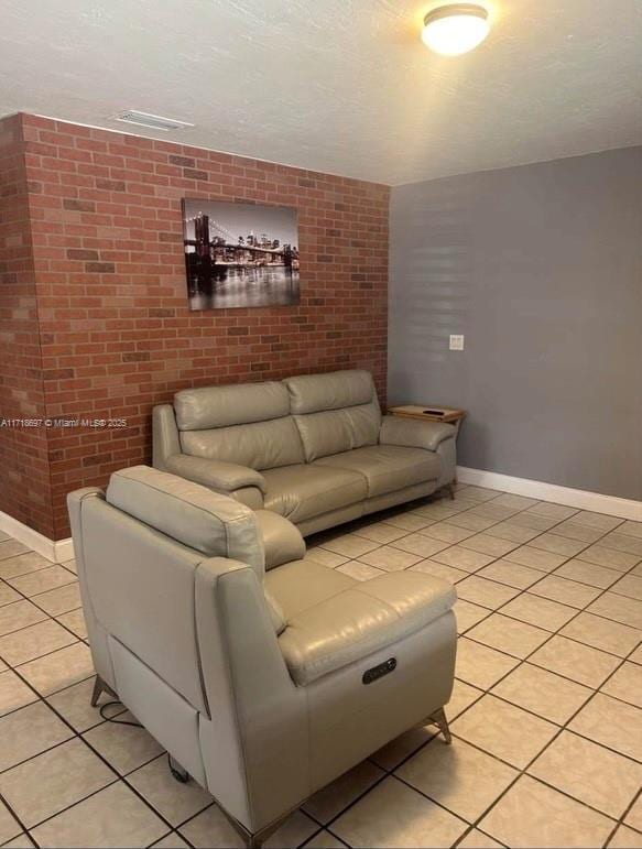 living room featuring brick wall and light tile patterned flooring