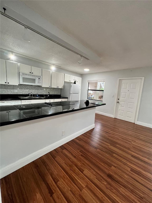 kitchen with white appliances, track lighting, white cabinetry, and sink