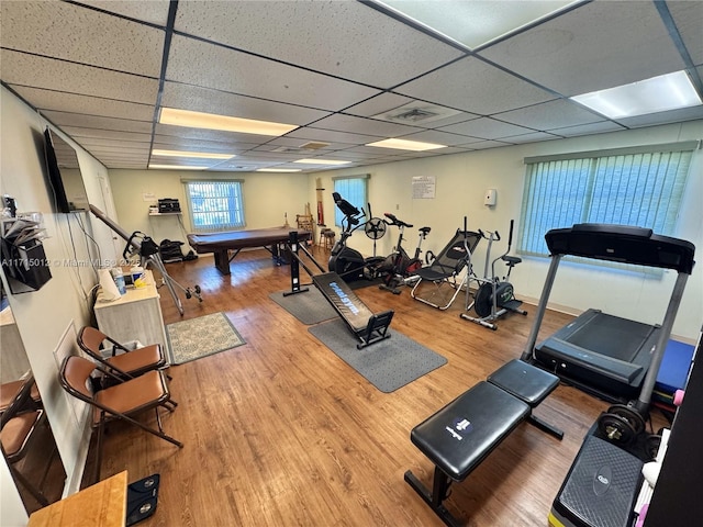 gym featuring a paneled ceiling and hardwood / wood-style flooring