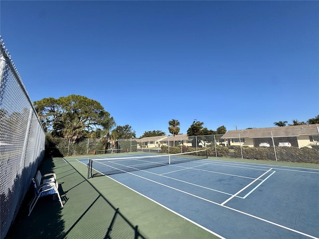 view of tennis court with basketball hoop