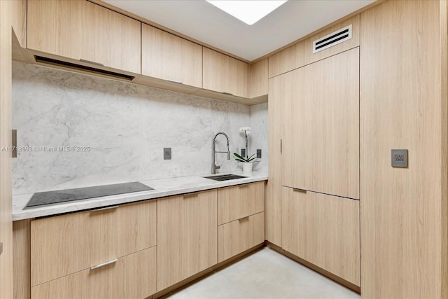 kitchen featuring decorative backsplash, sink, light brown cabinetry, and black electric stovetop