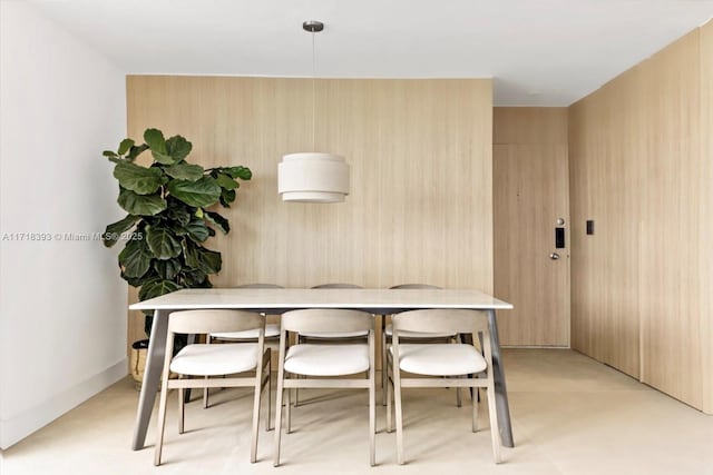 dining area featuring wood walls