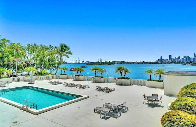 view of swimming pool featuring a patio and a water view