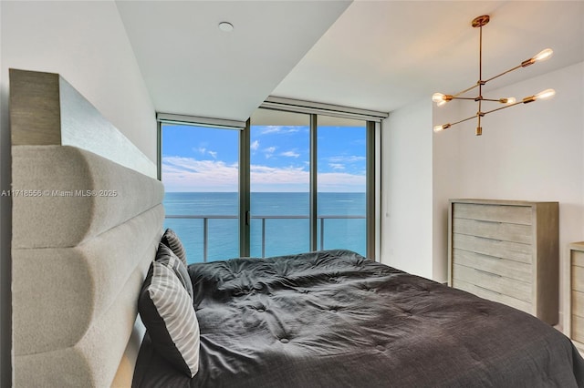 bedroom with multiple windows, access to outside, a water view, and floor to ceiling windows