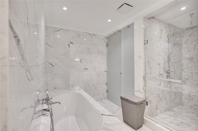 bathroom featuring plus walk in shower and tile walls